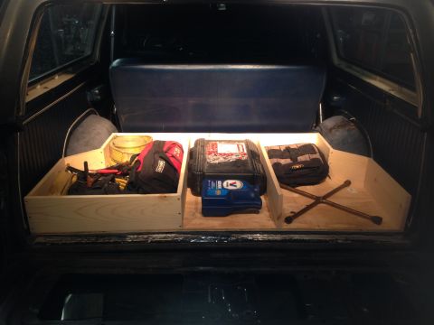1979 Ford Bronco - Custom storage box installed in the rear cargo area, holding various items and a spare tire jack.