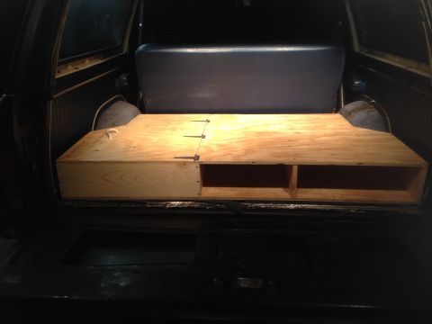 1979 Ford Bronco - A custom wooden storage box with multiple compartments has been installed in the rear cargo area of an SUV.