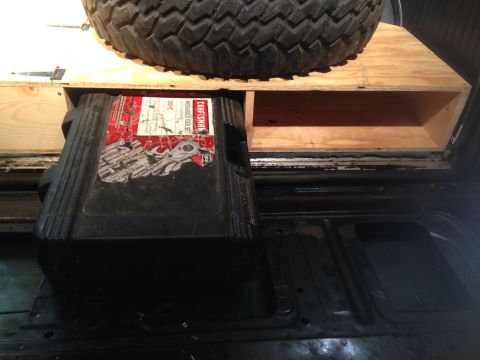1979 Ford Bronco - A Craftsman mechanics tool set is stored under a spare tire on a custom wooden platform.