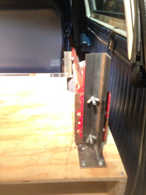 1979 Ford Bronco - A custom storage solution is being installed in the cargo area of a vehicle, a metal bracket and wooden platform.