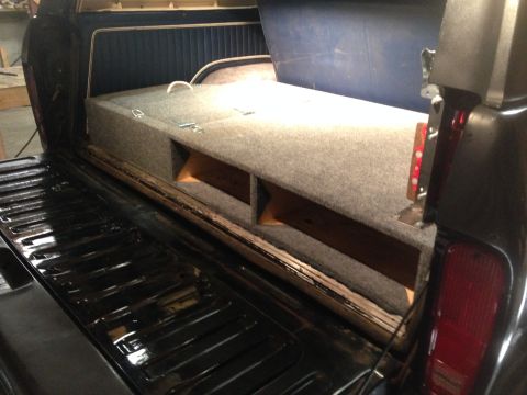 1979 Ford Bronco - A custom storage unit has been built into the bed of this pickup truck, a carpeted top and wooden compartments.