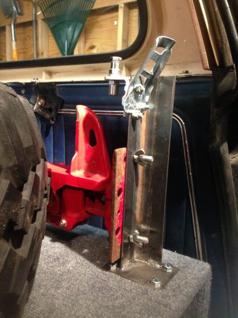 1979 Ford Bronco - A custom-fabricated bracket is mounted inside a vehicle, adjacent to a spare tire and storage area.