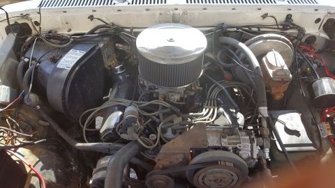 1978 Ford Bronco - Close-up view of a vehicle's engine compartment, showing the air filter, carburetor, and associated wiring and plumbing.