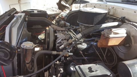 1978 Ford Bronco - Under-hood view showing a chrome-top air cleaner, master cylinder, radiator and tangled wiring of a V8 engine.