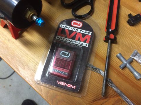 1989 Ford Bronco - Venom LVM Low Voltage Monitor packaging with tools on a wooden surface.