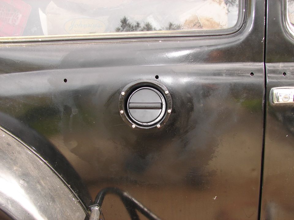 Black 1964 Volkswagen Beetle fuel filler door on the side of the vehicle