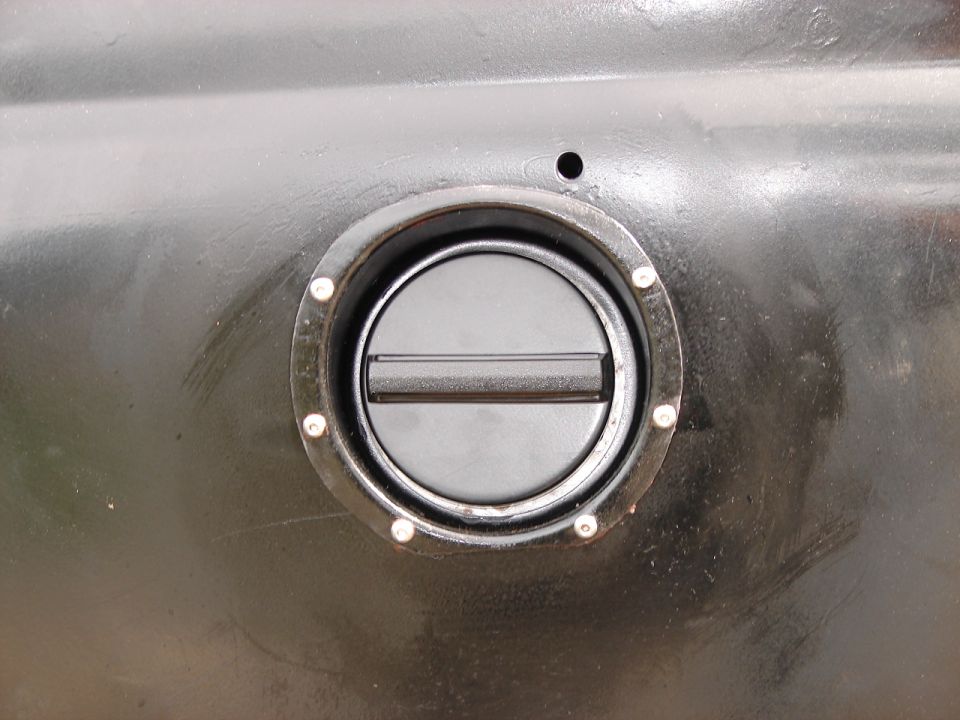 Black fuel filler cap on a dark vehicle body