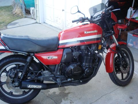 2008 Ford Crown Victoria - A red Kawasaki GP1100 motorcycle is parked in front of a garage door.
