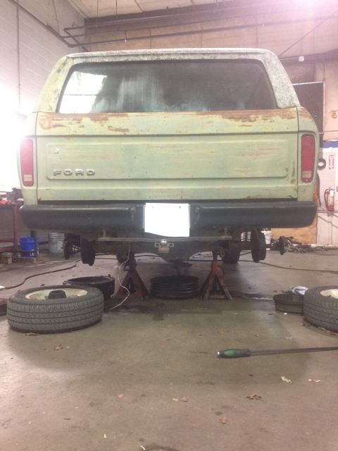 1978 Ford Bronco - Rear view of a green 1978 Ford Bronco undergoing repairs, showing its tailgate and rear bumper.