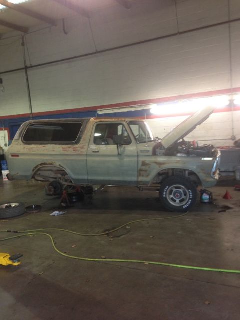 1978 Ford Bronco - A 1978 Ford Bronco is shown in a workshop with its hood open, indicating it is undergoing maintenance or repair.