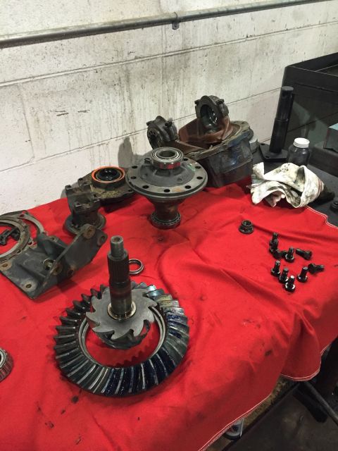 1978 Ford Bronco - Various differential parts and gears are spread out on a red cloth, suggesting a repair or rebuild process.