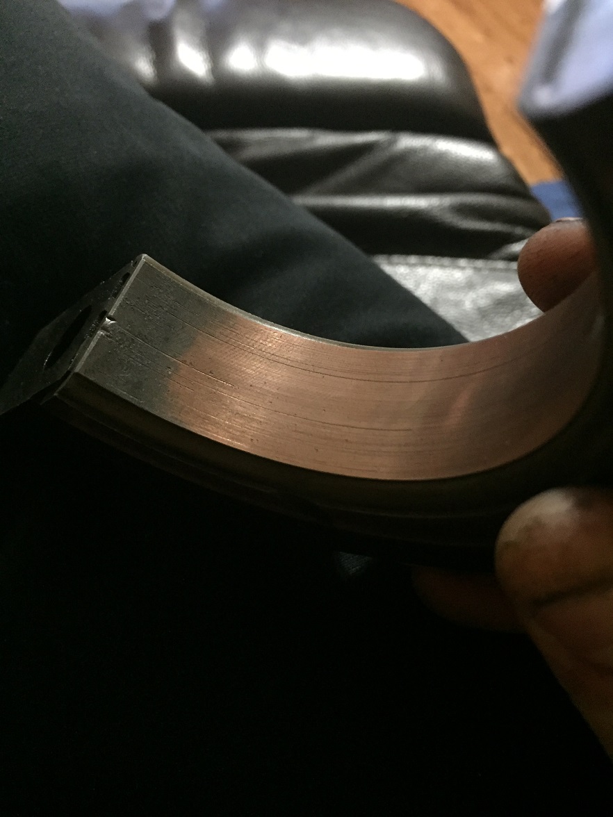 Close-up of a worn engine bearing with copper showing through