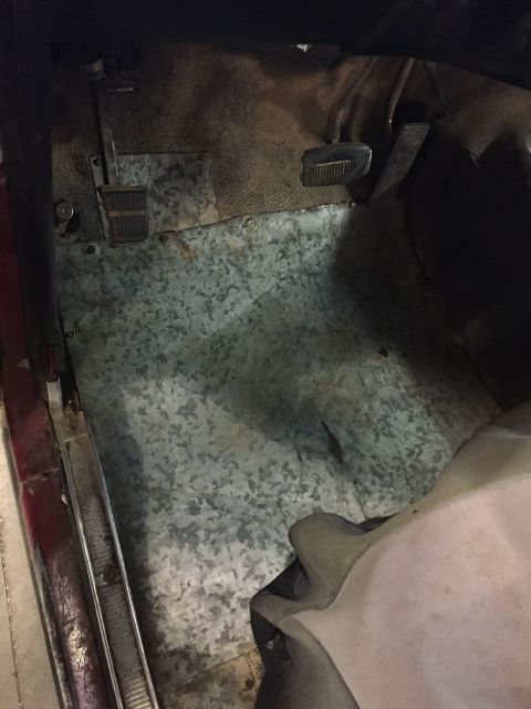 1978 Ford Bronco - The floor of a vehicle's interior shows metal sheeting and the brake and accelerator pedals.