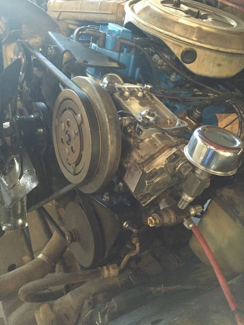 1978 Ford Bronco - Close-up view of the engine bay, focusing on the air conditioning system components and drive belts.