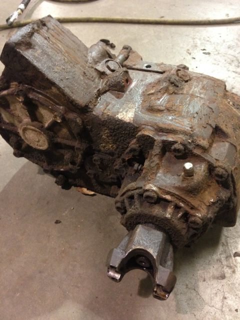 1978 Ford Bronco - Transfer case part, heavily rusted, with a U-joint yoke visible.