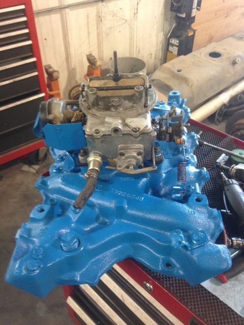 1978 Ford Bronco - A bright blue engine manifold with a carburetor is shown, a visible part number.