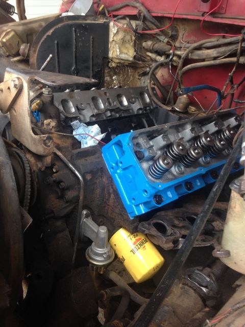 1978 Ford Bronco - Engine components, including a blue valve cover and oil filter, are shown during a repair.