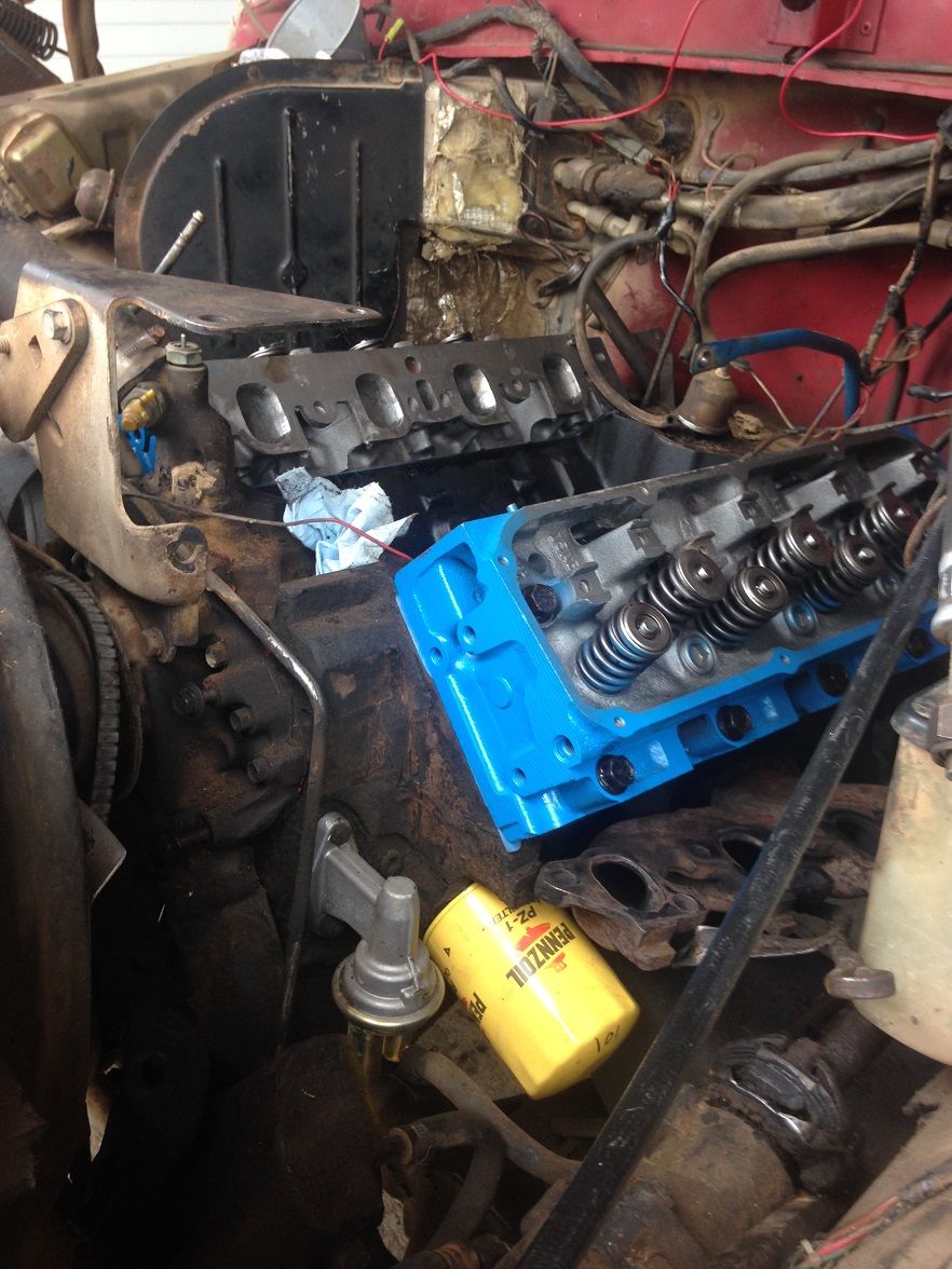Engine block with blue valve cover, oil filter, and fuel pump visible