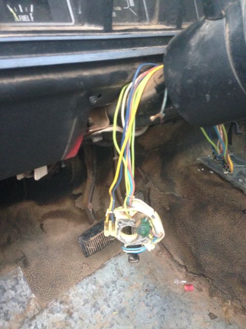1978 Ford Bronco - Exposed wiring harness and fuel gauge in a vehicle's dashboard area.