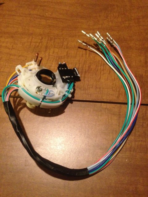 1978 Ford Bronco - A vehicle's turn signal switch assembly with a bundle of multicolored wires is shown on a wooden surface.