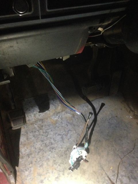 1978 Ford Bronco - The steering column wiring harness is disconnected, and the brake and gas pedals are visible on the floor.