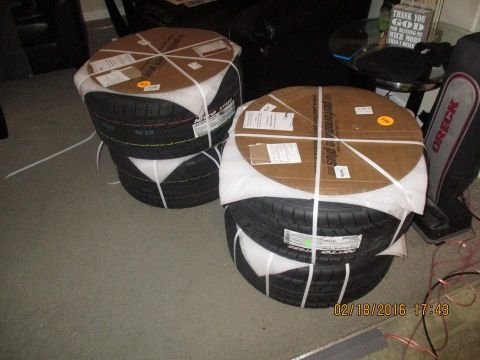 2004 Ford Crown Victoria - Two stacks of new tires are shown, each secured with cardboard and white strapping.
