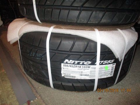 2004 Ford Crown Victoria - Two new Nitto NT555 tires are stacked and secured with white straps, ready for installation.