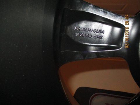2004 Ford Crown Victoria - A close-up view of a car wheel shows manufacturing details and a date stamp of 02/18/2015.