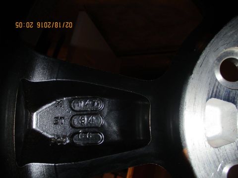 2004 Ford Crown Victoria - Close-up of a black alloy wheel showing manufacturing codes and bolt pattern information.