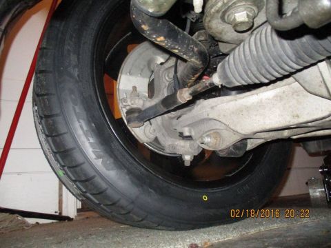 2004 Ford Crown Victoria - This image shows the underside of a vehicle's front wheel, including the tire, brake, and suspension parts.