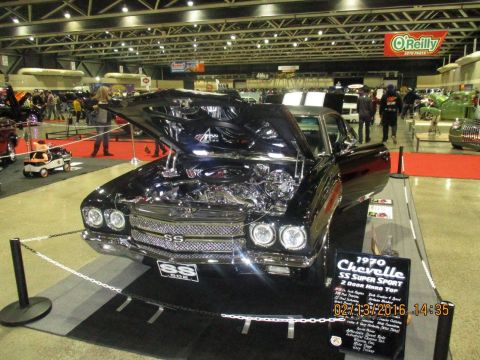 2004 Ford Crown Victoria - A black 1970 Chevrolet Chevelle SS Super Sport is on display with its hood open, revealing the engine.