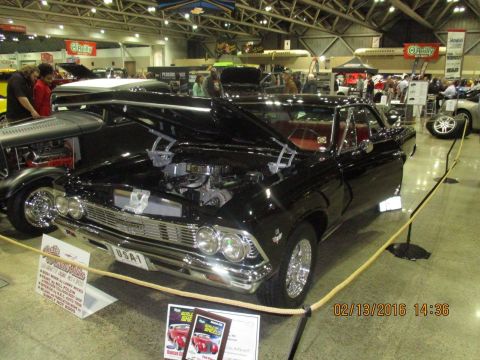 2004 Ford Crown Victoria - A black 1964 Chevrolet Chevelle SS is displayed with its hood open, revealing the engine bay.