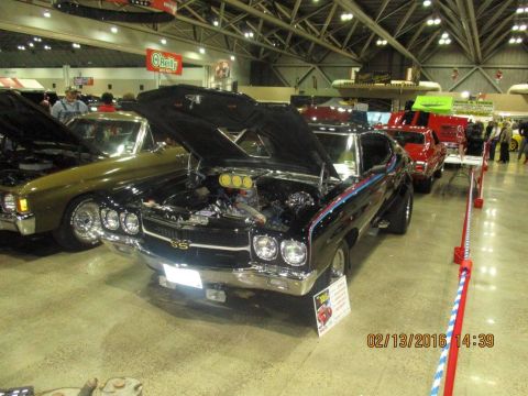 2004 Ford Crown Victoria - A black 1970 Chevrolet Chevelle SS is displayed with its hood open at a car show.