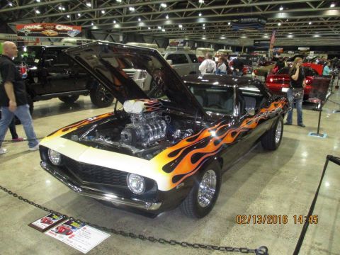 2004 Ford Crown Victoria - Customized muscle car with flames and exposed engine at a show.