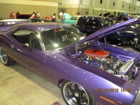 2004 Ford Crown Victoria - A purple muscle car is displayed indoors with its hood open, revealing the engine bay.