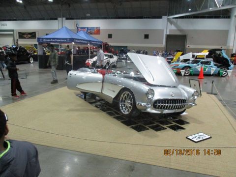2004 Ford Crown Victoria - Silver 1956 Chevrolet Corvette convertible displayed with its hood open, a red and silver interior.