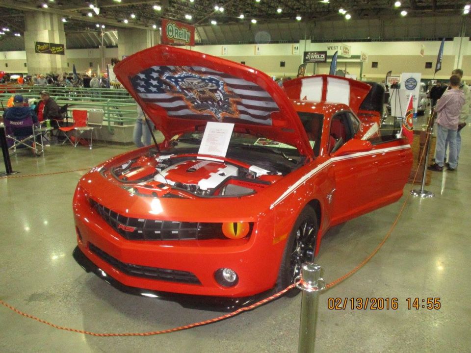 Red Chevrolet Camaro with hood and driver's door open, custom American flag decal under hood