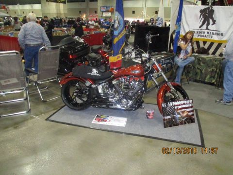 2004 Ford Crown Victoria - Custom motorcycle on display at an indoor event, with flags and people in the background.