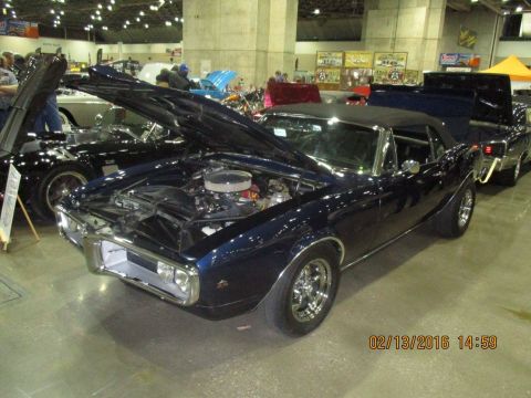 2004 Ford Crown Victoria - Dark blue 1967 Pontiac Firebird convertible on display with its hood open.