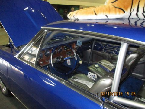 2004 Ford Crown Victoria - The interior of a custom blue car features flame detailing on the door panels and a plush tiger on the roof.