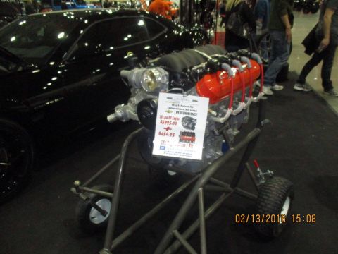 2004 Ford Crown Victoria - A V8 engine is displayed on a stand at an event, with a black car visible in the background.