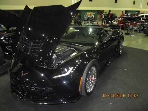 2004 Ford Crown Victoria - Black convertible sports car with hood open at an indoor event. Date stamp 02/13/2016.