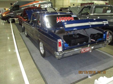 2004 Ford Crown Victoria - A dark blue classic car, possibly a 1967 model, is displayed with its trunk open, revealing a fuel cell and other equipment.