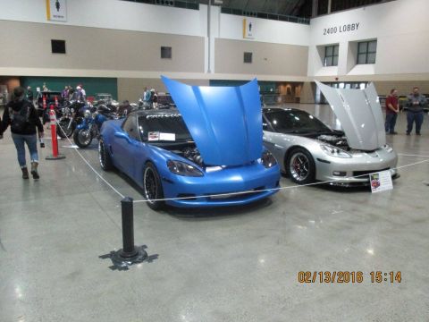 2004 Ford Crown Victoria - Two sports cars are displayed indoors with their hoods open, suggesting an exhibition or show.