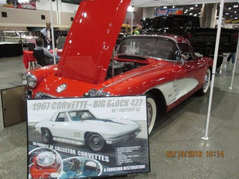 2004 Ford Crown Victoria - A red 1967 Corvette is displayed with its hood open, alongside a sign detailing its features and a picture of a white Corvette.