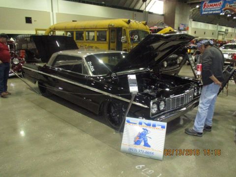 2004 Ford Crown Victoria - Customized 1964 Chevrolet Impala on display at a car show, with its hood open.
