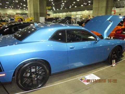 2004 Ford Crown Victoria - Blue Dodge Challenger on display at a car show, with other vehicles visible in the background.