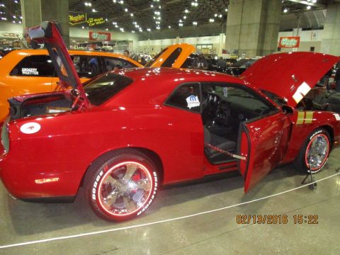 2004 Ford Crown Victoria - A red Dodge Challenger is displayed with its doors and hood open at an indoor event.