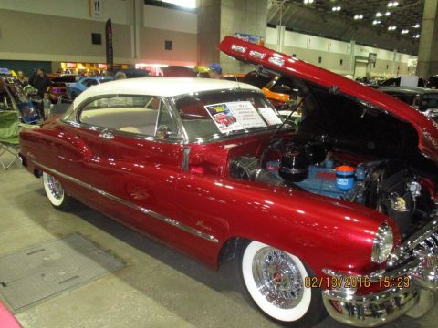 2004 Ford Crown Victoria - A shiny red classic coupe with a white roof is displayed with its hood open, revealing the engine compartment.