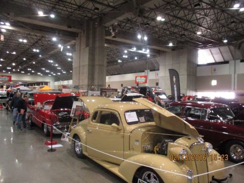 2004 Ford Crown Victoria - Multiple classic cars displayed indoors at a car show event.